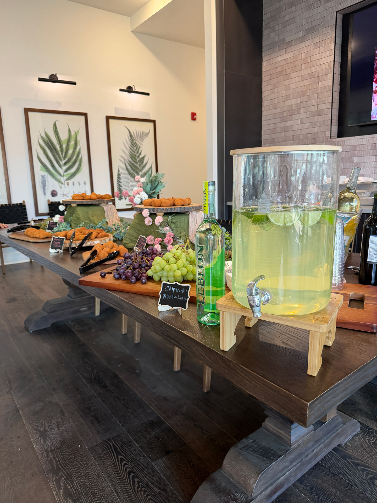 Caipirinha punch, cachaça, and Venezuelan appetizers on a grazing table at a resident culture night at Town Kennesaw in Kennesaw, GA