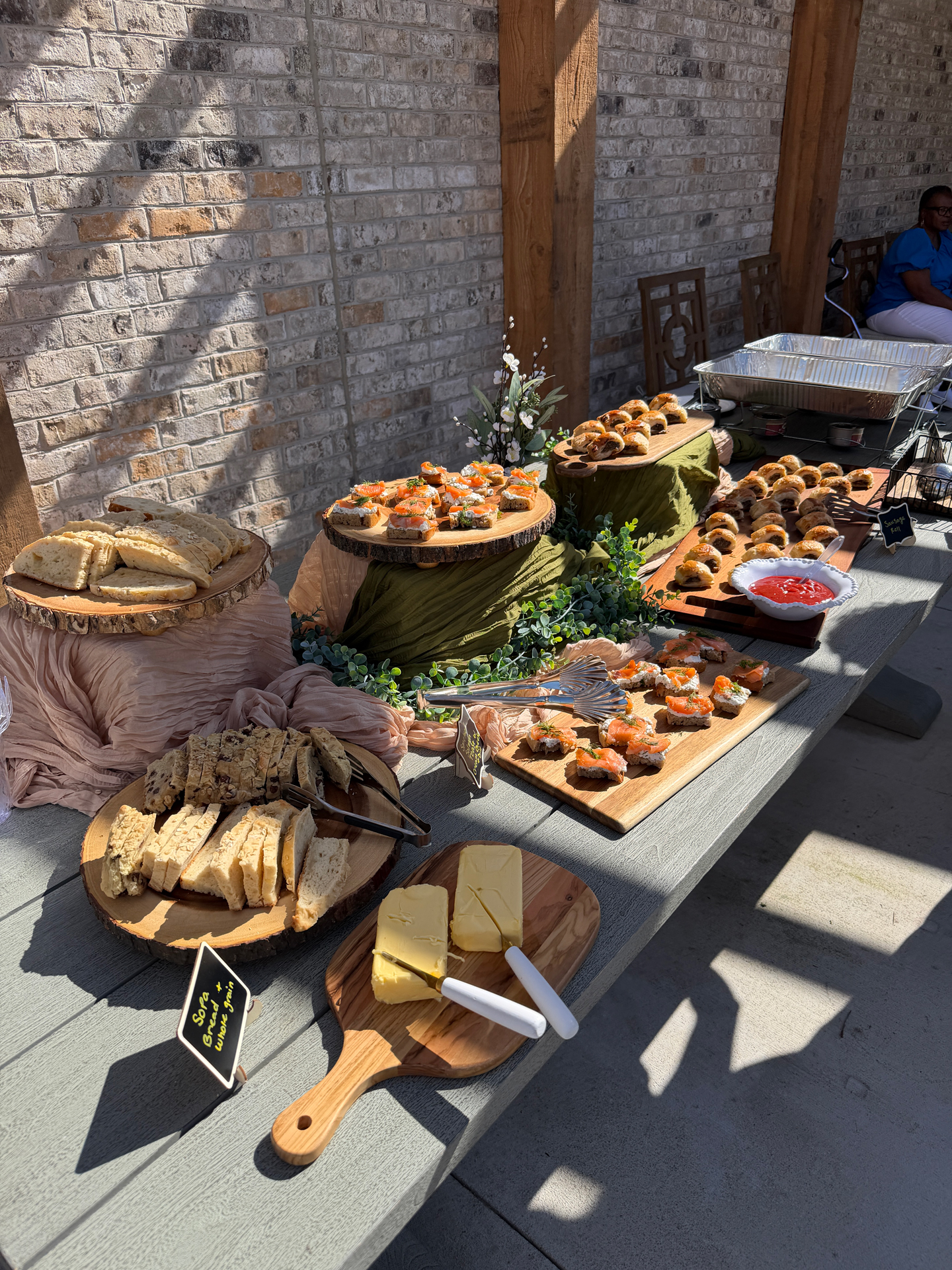 Outdoor brunch spread with breads, smoked salmon toasts, and sausage rolls at a Town Kennesaw resident event in Kennesaw, GA
