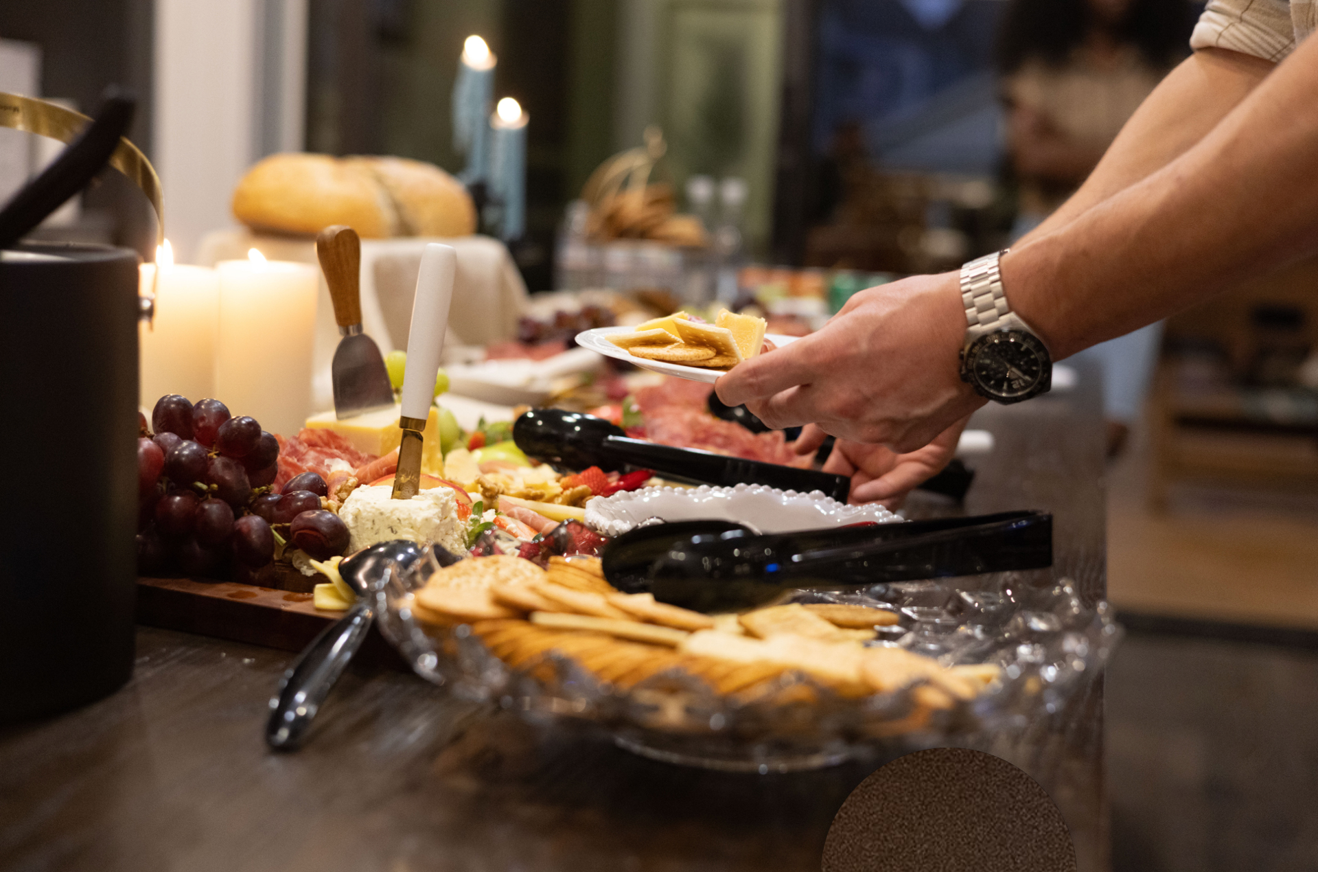 Resident serving cheese and crackers from a charcuterie grazing board at an evening event at Town Kennesaw in Kennesaw, GA